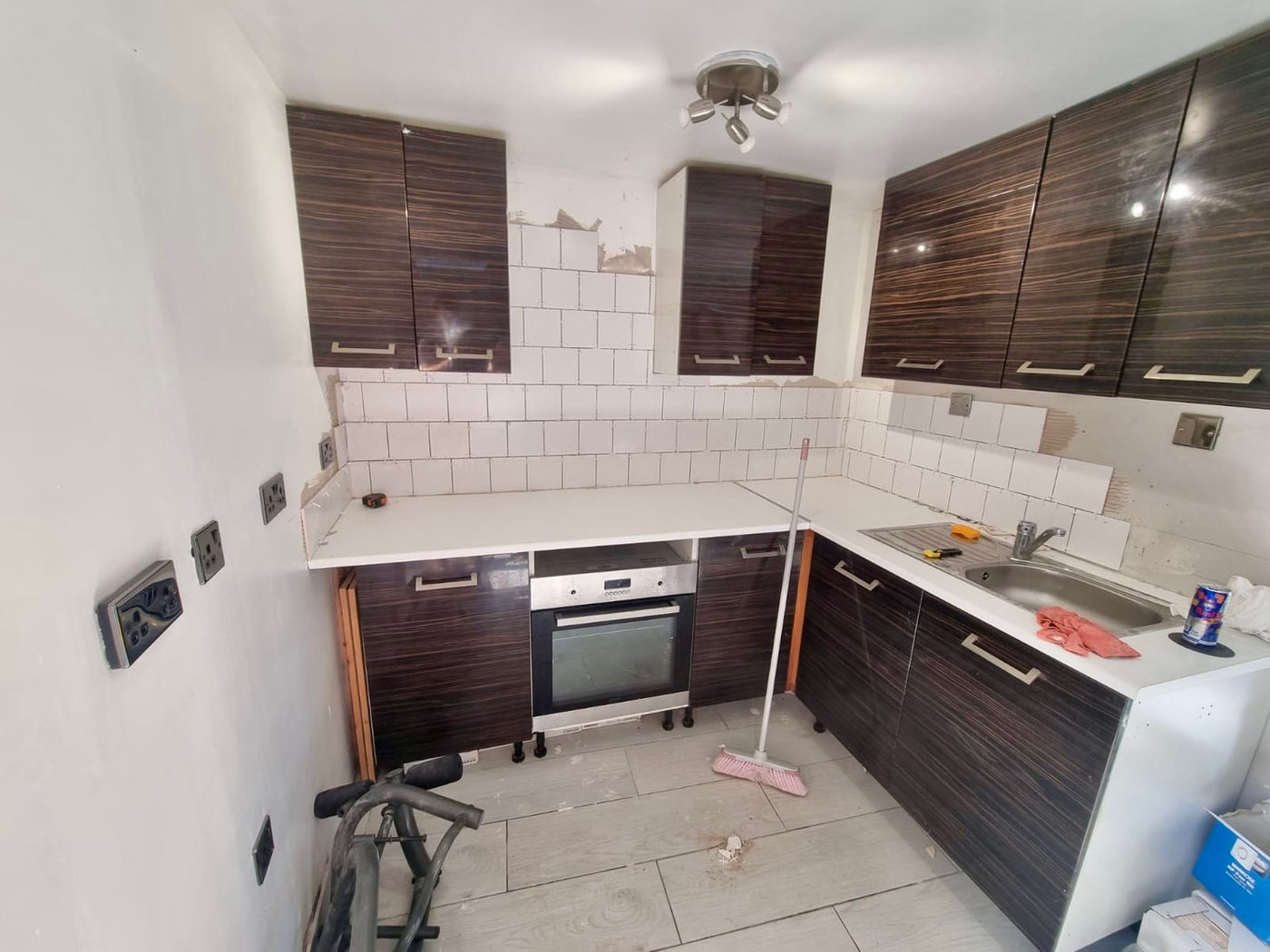 Kitchen work with tiled wall area, cabinets and flooring