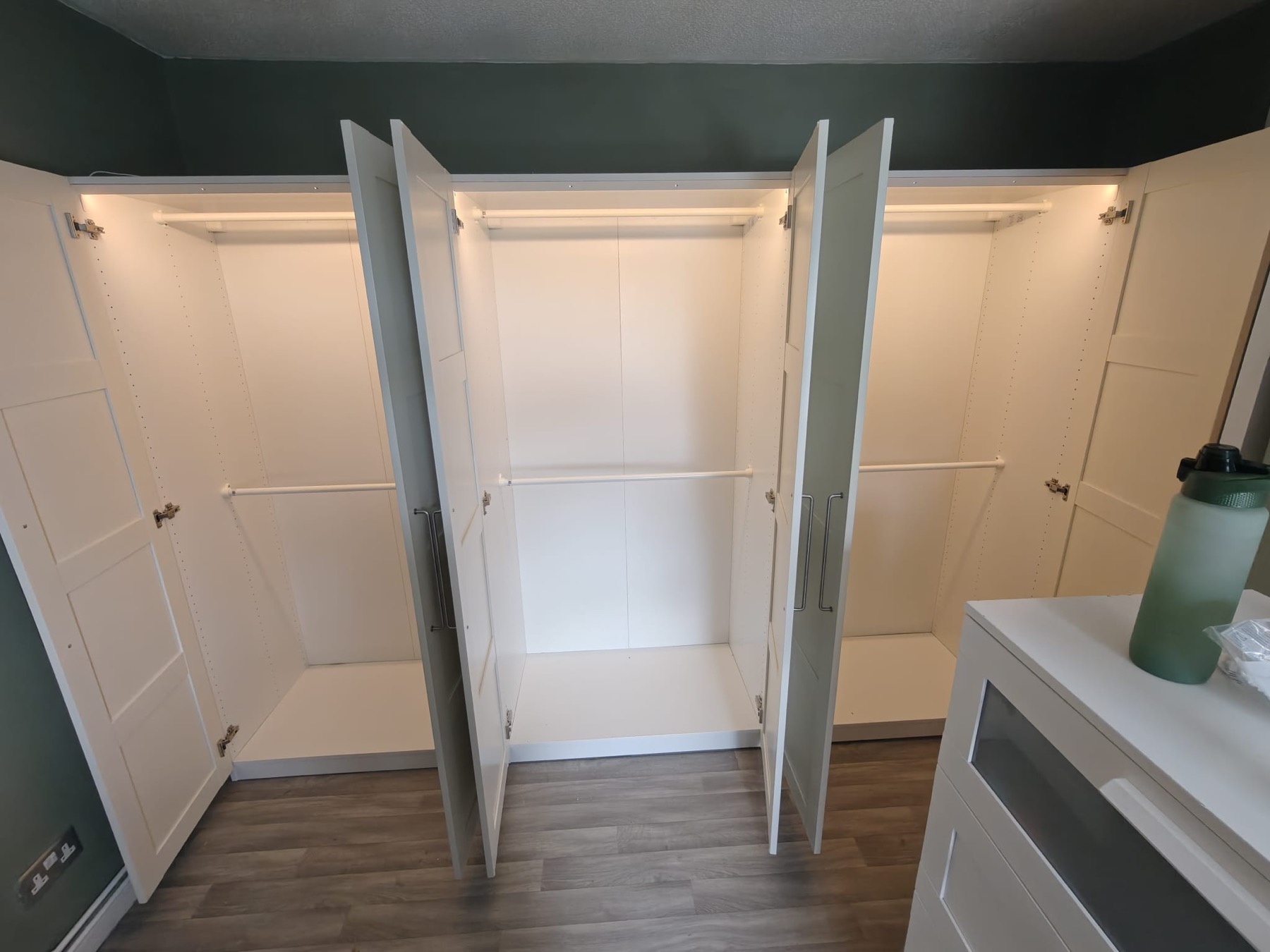 Fitted wardrobe assembly with open doors, internal rails and shelving