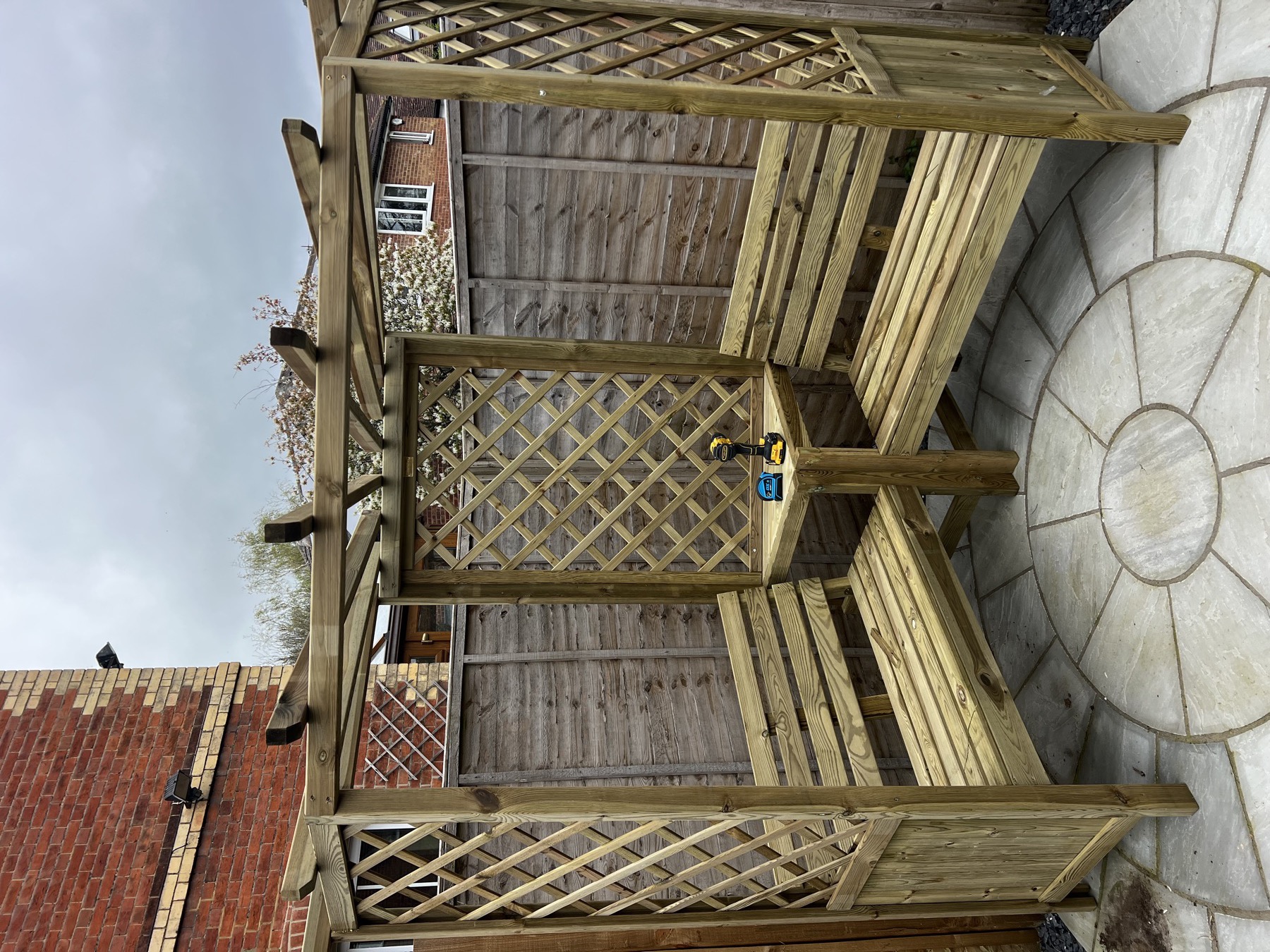 Garden pergola seating and timber frame assembled on a paved patio